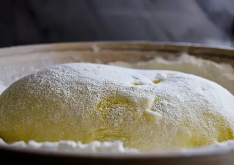 Shaped dough resting under a dusting of flour